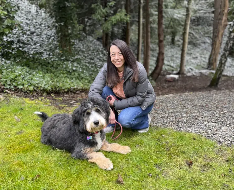 Woman crouching next to dog